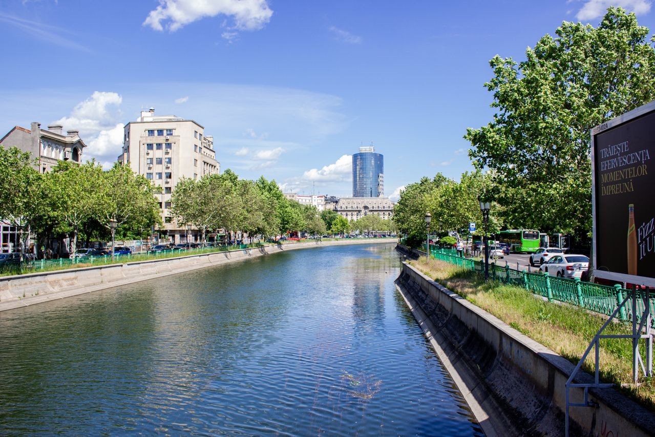 Canalul Dâmbovița din centrul Bucureștiului, cu clădiri istorice și panoramă urbană